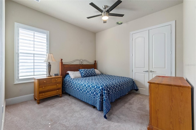 carpeted bedroom featuring ceiling fan and a closet