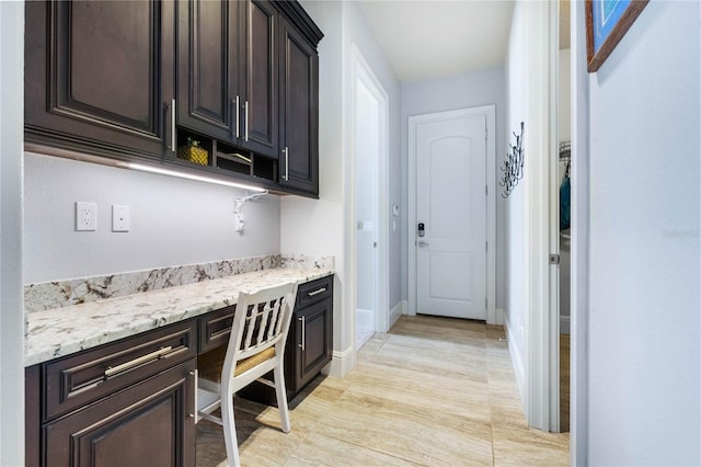 interior space with light stone counters and built in desk