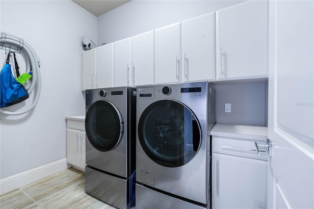 washroom with cabinets and washer and dryer