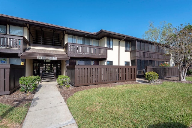 48 Club House Dr Unit 106, Palm Coast, FL 32137 - rear view of house featuring stucco siding, stairs, and a lawn