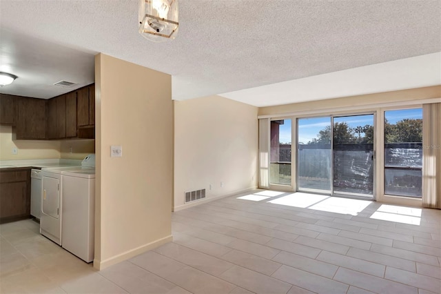 48 Club House Dr Unit 106, Palm Coast, FL 32137 - spare room with baseboards, visible vents, washer and dryer, and a textured ceiling
