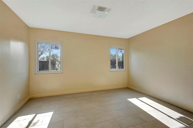48 Club House Dr Unit 106, Palm Coast, FL 32137 - unfurnished room featuring a wealth of natural light, baseboards, and light tile patterned floors