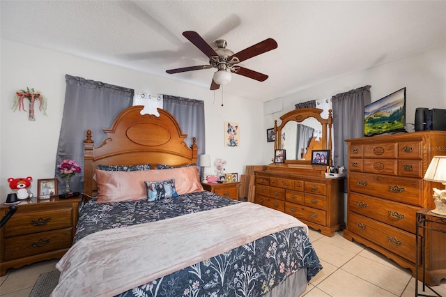 bedroom featuring light tile patterned flooring, ceiling fan, and a textured ceiling