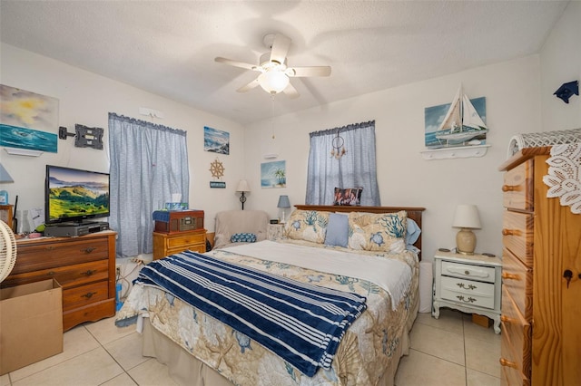 bedroom featuring ceiling fan, a textured ceiling, and light tile patterned floors