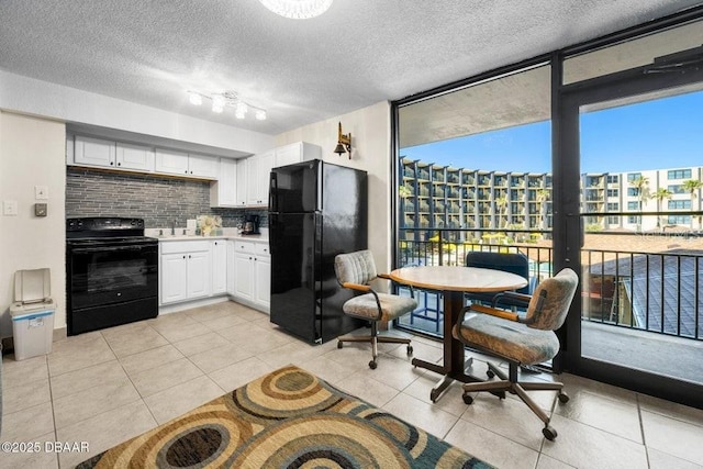 kitchen featuring floor to ceiling windows, tasteful backsplash, black appliances, white cabinets, and light tile patterned flooring