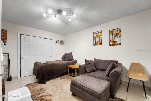 bedroom with light tile patterned flooring, a textured ceiling, and a closet