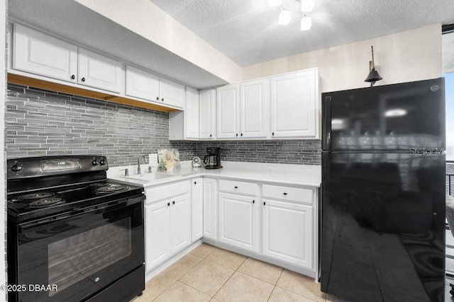 kitchen featuring light tile patterned flooring, sink, white cabinets, decorative backsplash, and black appliances