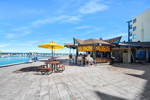 view of patio / terrace with a water view and exterior bar