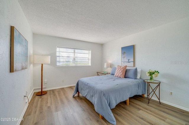 bedroom with hardwood / wood-style flooring and a textured ceiling