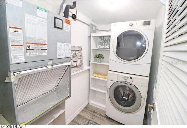 washroom with stacked washer and clothes dryer, dark wood-type flooring, and heating unit