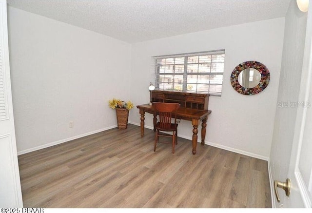 office area with hardwood / wood-style floors and a textured ceiling