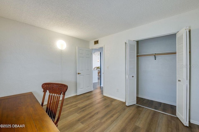 interior space featuring dark hardwood / wood-style flooring, a closet, and a textured ceiling