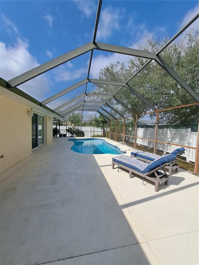 view of swimming pool featuring a patio and a lanai