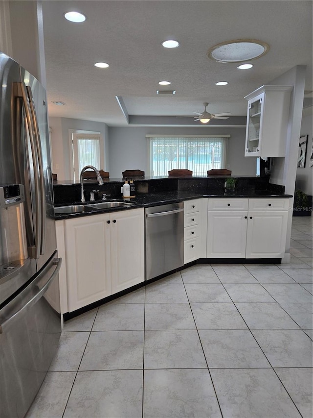 kitchen with a healthy amount of sunlight, stainless steel appliances, sink, and white cabinets