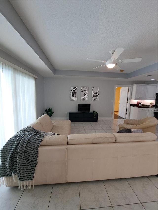 living room featuring ceiling fan and a textured ceiling