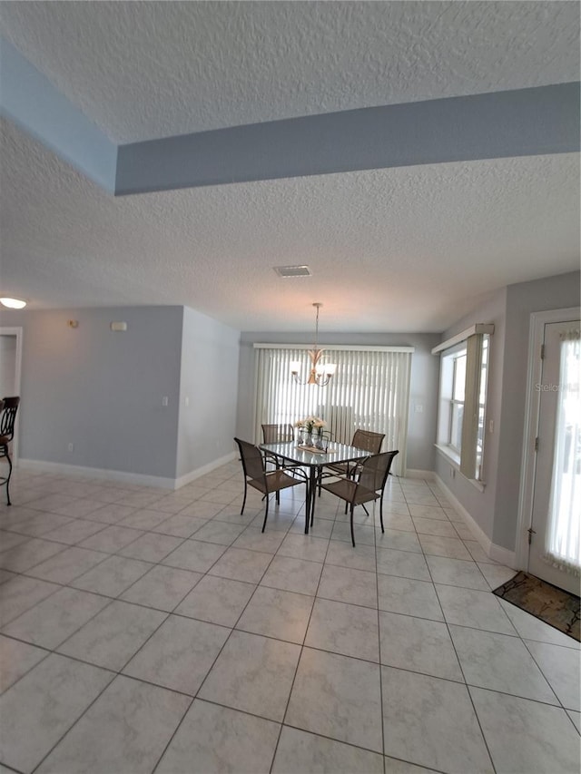 dining room featuring a chandelier, light tile patterned floors, and a textured ceiling