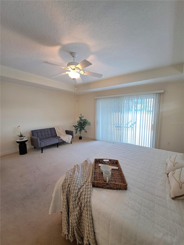 carpeted bedroom with ceiling fan and a textured ceiling