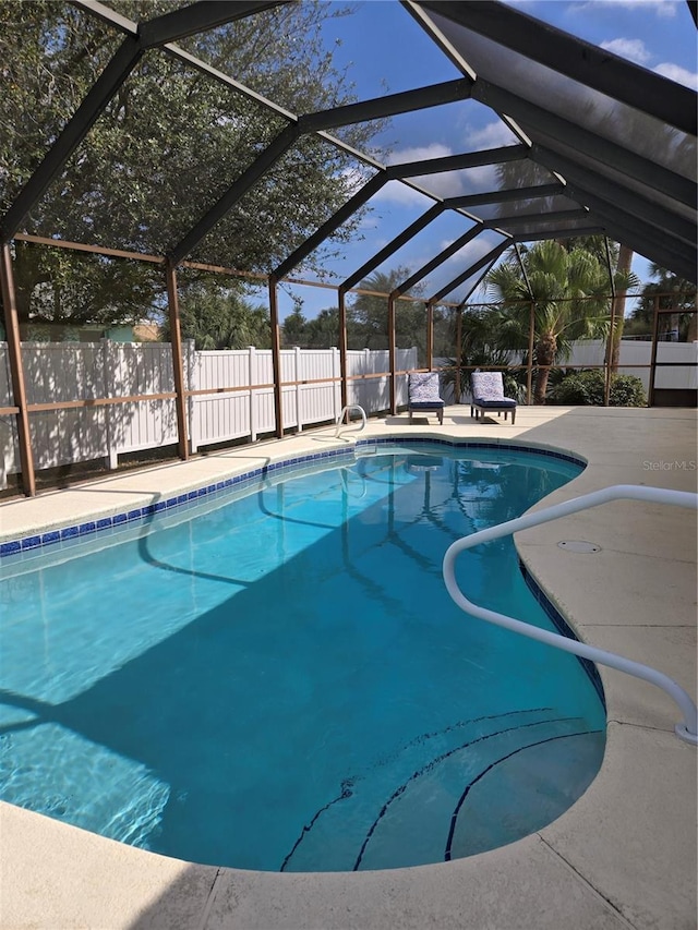 view of swimming pool with a patio area and glass enclosure