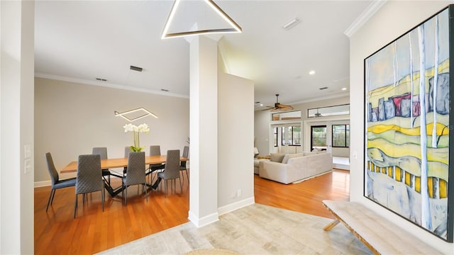 dining room with crown molding and light hardwood / wood-style flooring