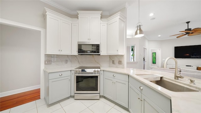 kitchen with sink, tasteful backsplash, ornamental molding, appliances with stainless steel finishes, and pendant lighting