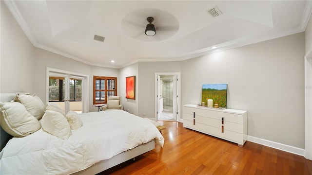 bedroom with hardwood / wood-style floors, crown molding, and ensuite bathroom