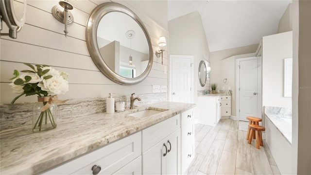 bathroom featuring vanity and lofted ceiling