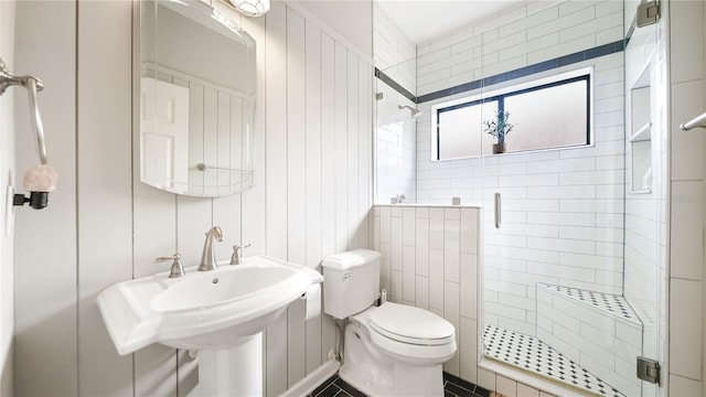 bathroom with an enclosed shower, sink, and toilet