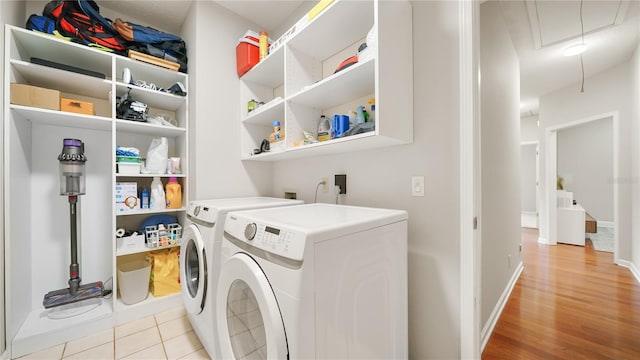 clothes washing area with separate washer and dryer and light wood-type flooring