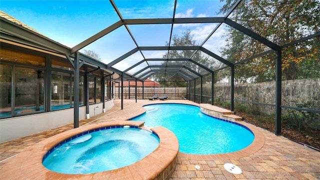 view of pool with an in ground hot tub, a lanai, and a patio