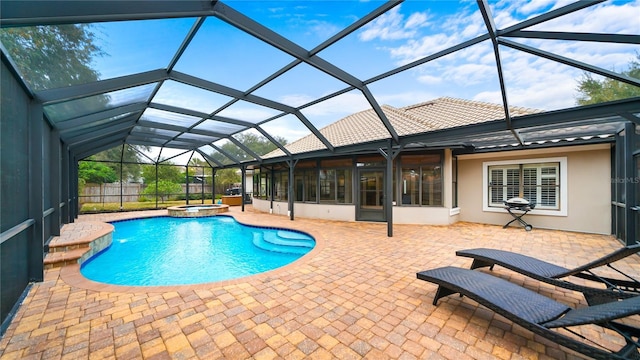 view of pool with an in ground hot tub, a sunroom, glass enclosure, and a patio area