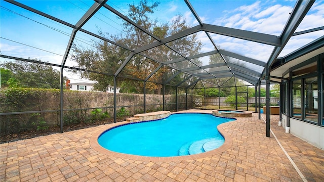 view of pool featuring a lanai, a patio area, and an in ground hot tub