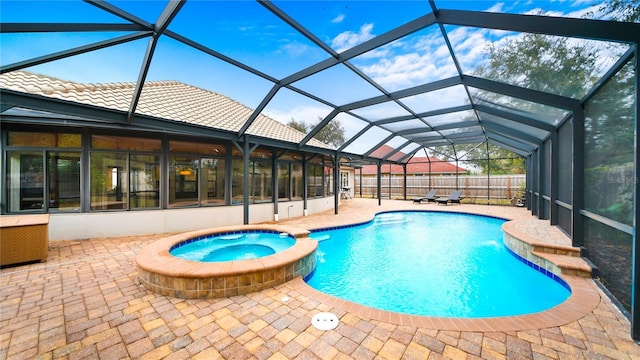 view of pool featuring an in ground hot tub, a patio, and glass enclosure