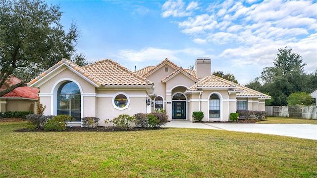 mediterranean / spanish home featuring a front yard