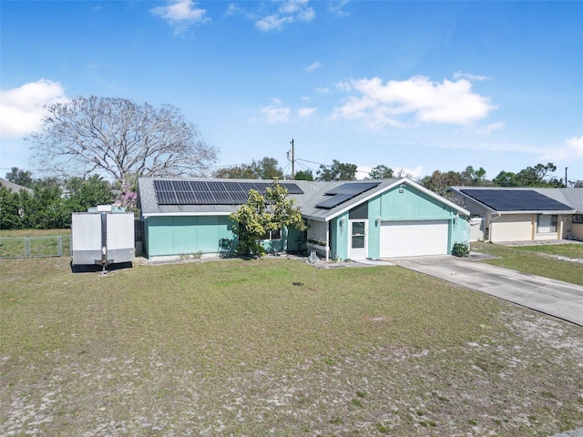 ranch-style home with a front lawn, solar panels, and a garage