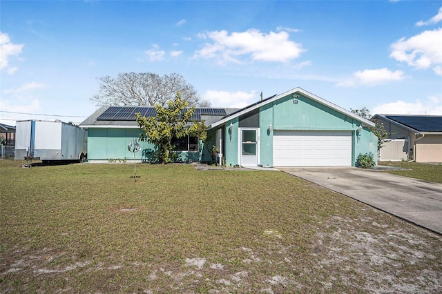 view of front facade with a front lawn, solar panels, and a garage