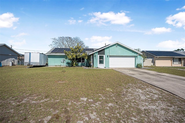 view of front facade with a front lawn, solar panels, and a garage