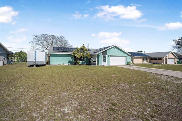 ranch-style house with a front lawn, solar panels, and a garage