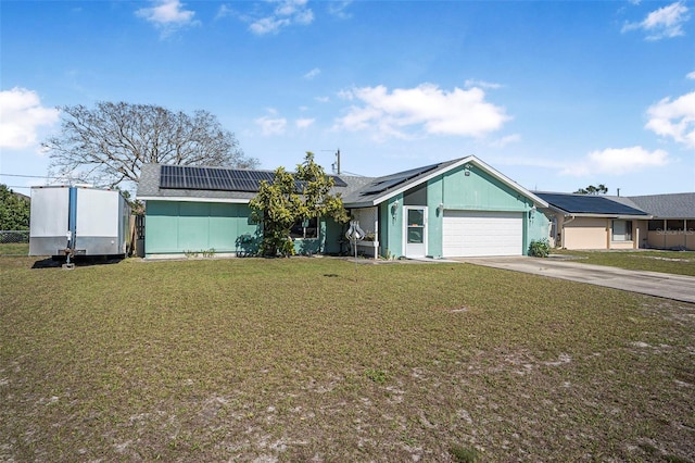 ranch-style house featuring a front lawn, solar panels, and a garage