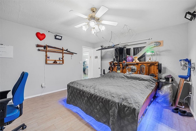 bedroom featuring ceiling fan, wood-type flooring, and a textured ceiling