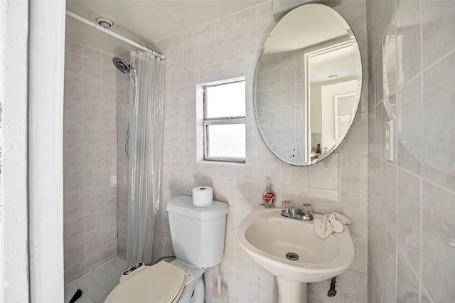 bathroom featuring sink, toilet, tile walls, tasteful backsplash, and walk in shower