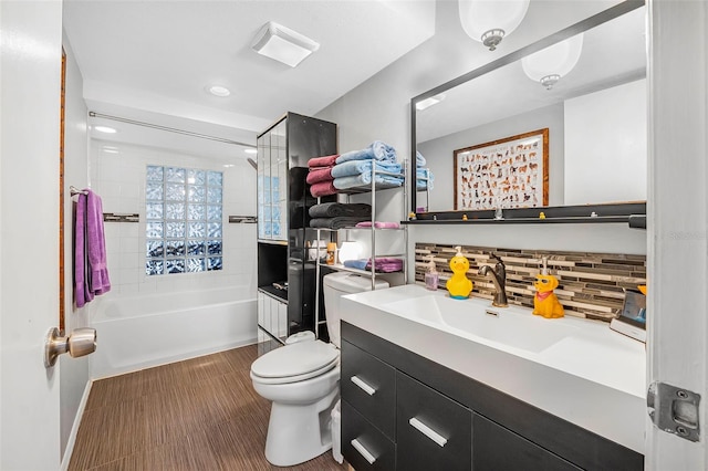 full bathroom with vanity, backsplash, toilet, and tiled shower / bath