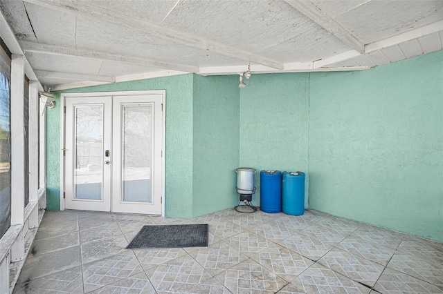 unfurnished sunroom with french doors and beamed ceiling