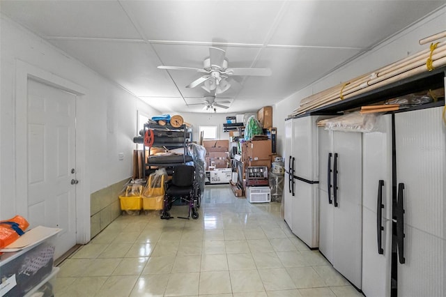 basement featuring ceiling fan and light tile patterned floors