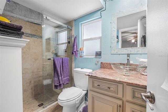 bathroom with toilet, vanity, and a shower with door