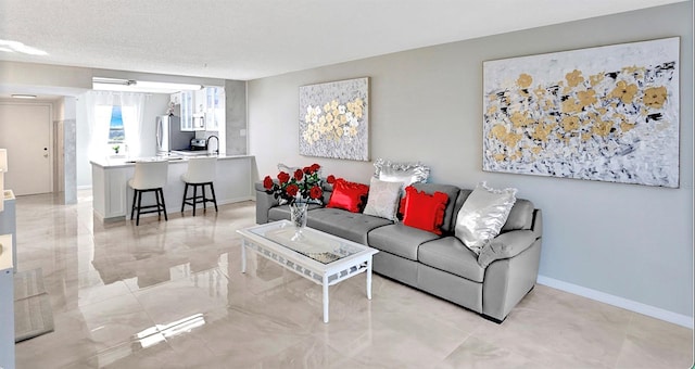 living area featuring baseboards and a textured ceiling