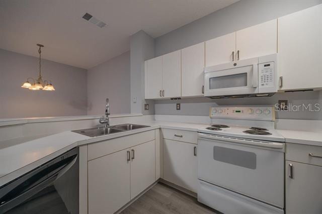 kitchen featuring sink, white appliances, white cabinetry, decorative light fixtures, and light wood-type flooring