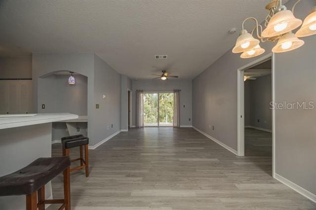 interior space with a textured ceiling, light hardwood / wood-style flooring, and ceiling fan