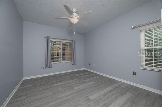 spare room with wood-type flooring, ceiling fan, and a textured ceiling