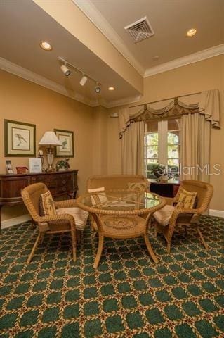 sitting room featuring ornamental molding and carpet floors