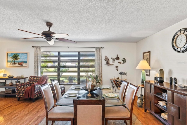 dining room featuring ceiling fan, wood-type flooring, and a textured ceiling